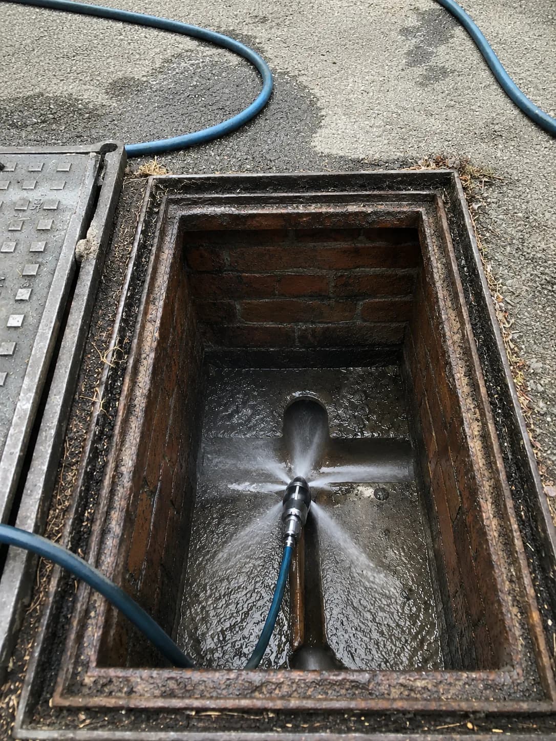 High-pressure drain jetting cleaning a sewer structure